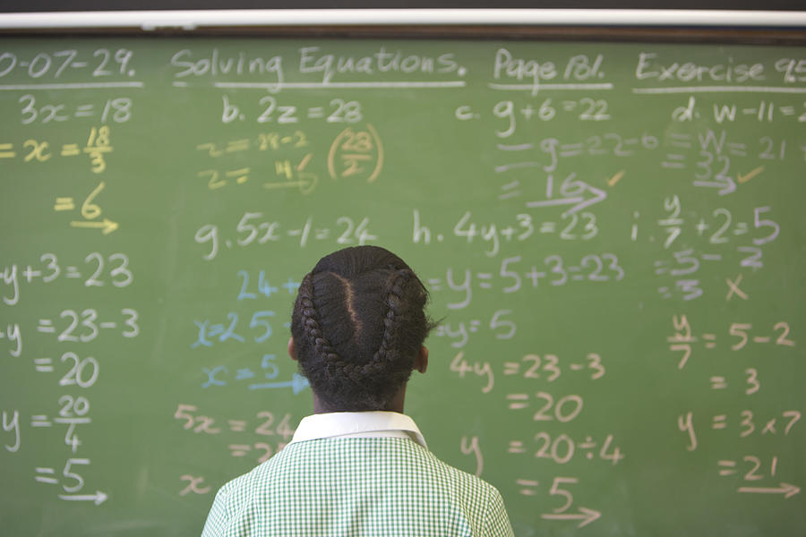 Schoolgirl looking at chalkboard with algebra sums, KwaZulu Natal Province, South Africa Photograph by Stuart Fox