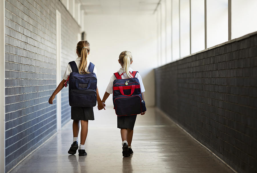 Schoolgirls walking hand in hand at school isle Photograph by Klaus Vedfelt