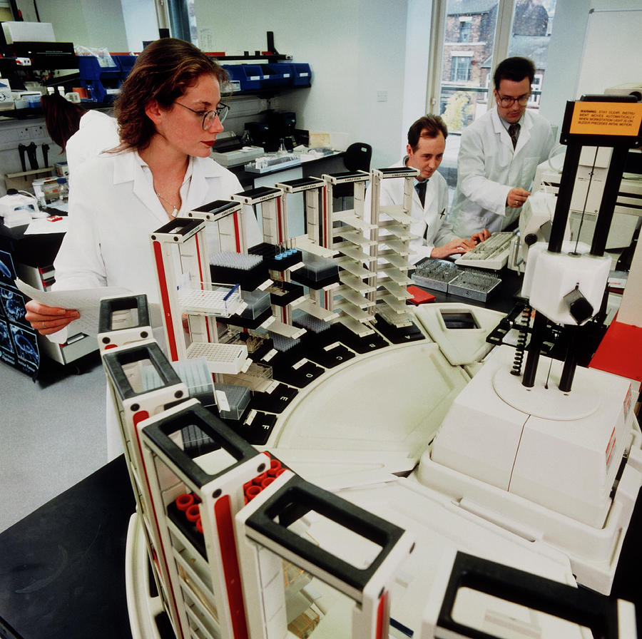 Scientists With Automated Immunochemical Analyser Photograph by Crown Copyright/health & Safety Laboratory /science Photo Library