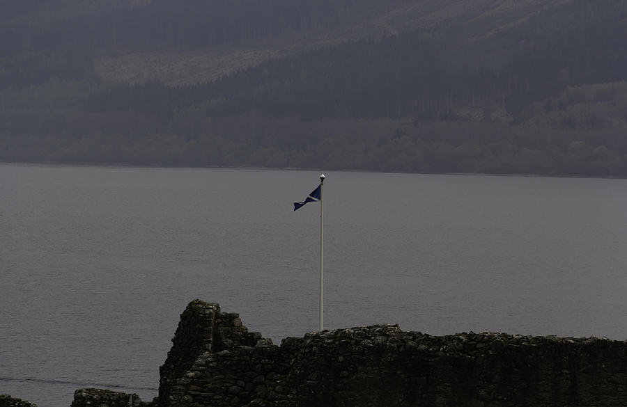 Scottish flag flying high over the remains of Urquhart Castle Photograph by Ashish Agarwal