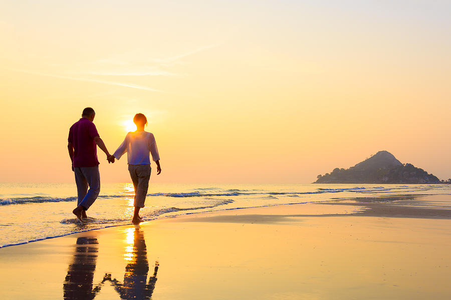 Senior couple at golden beach Photograph by FredFroese