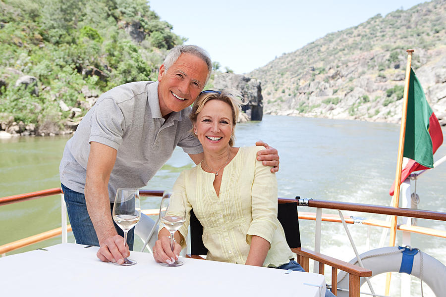 Senior couple with glasses of wine on a boat holiday Photograph by Image_Source_