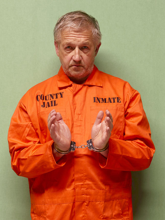 Senior man in hand cuffs Photograph by Peter Dazeley