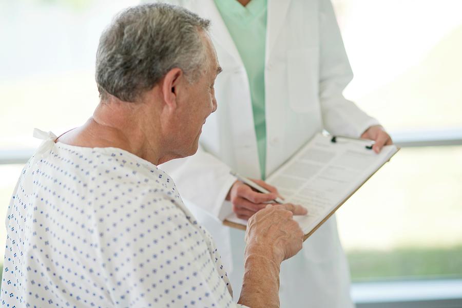 Senior Man Pointing At Medical Notes In Hospital Photograph by Science Photo Library