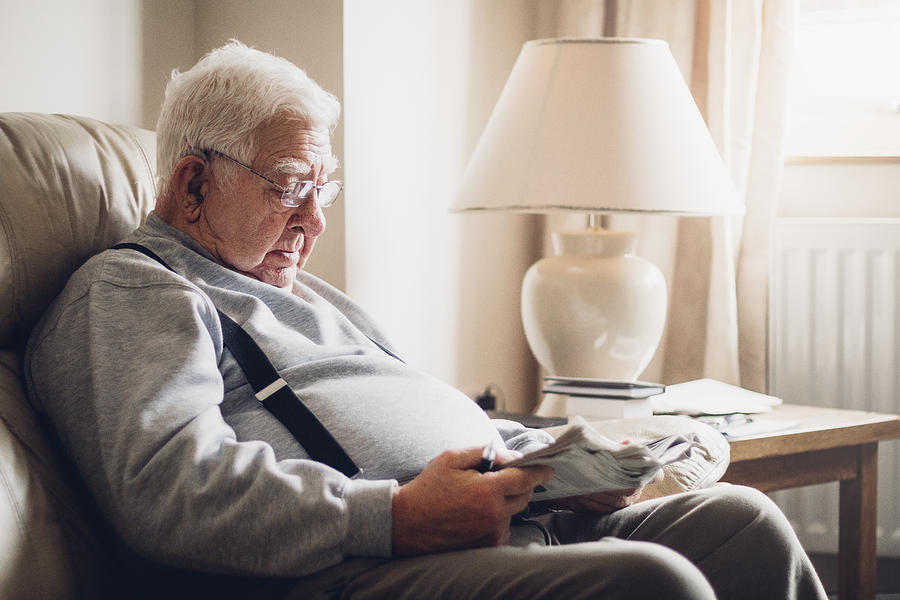 Senior Man Reading his Newspaper Photograph by SolStock