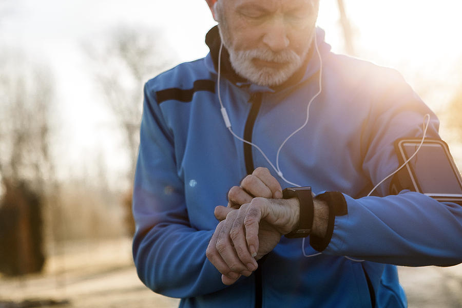 Senior Man using Smart Watch measuring heart rate Photograph by Nastasic