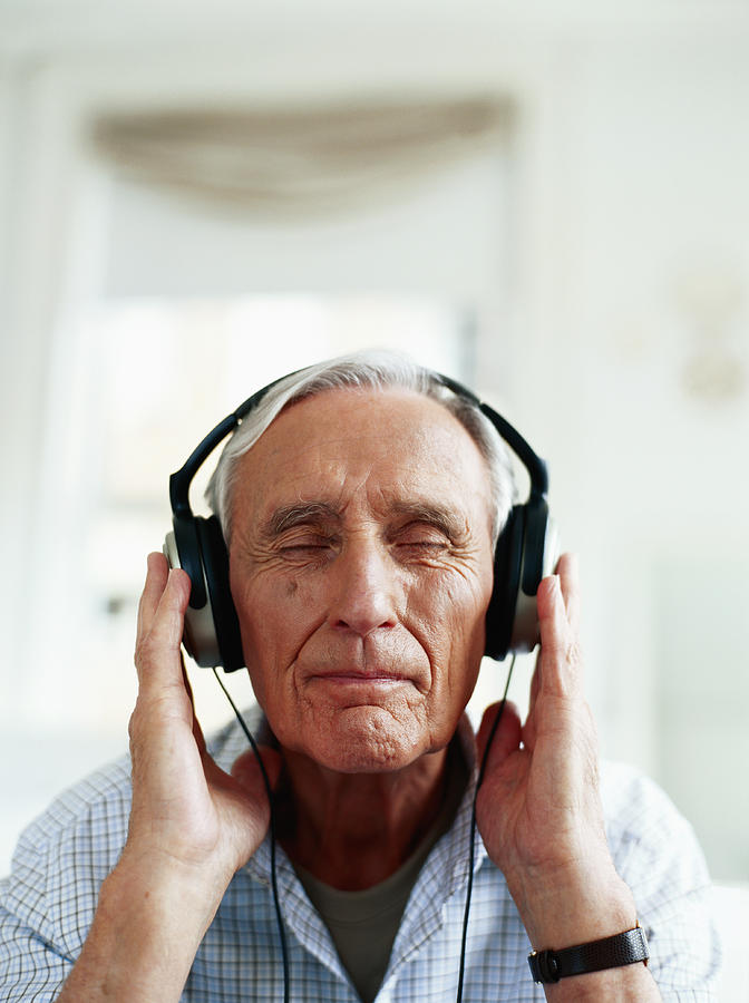 Senior man wearing headphones, eyes closed, close-up Photograph by Stockbyte