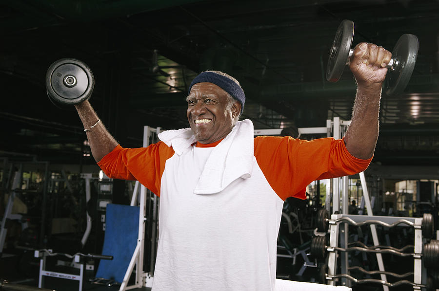 Senior man weight training in gym Photograph by Barry Austin