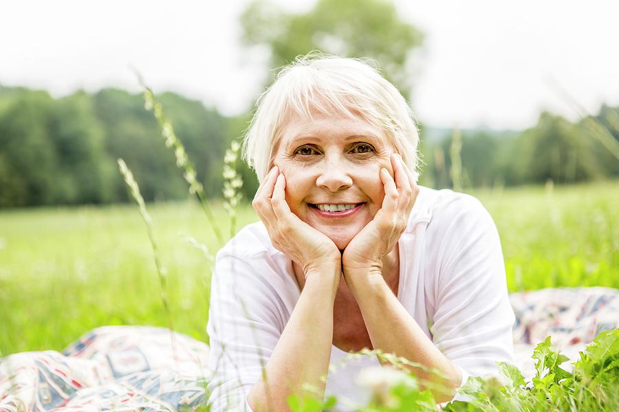 Senior Woman Lying On Grass With Hands On Chin Photograph By Science Photo Library Fine Art 