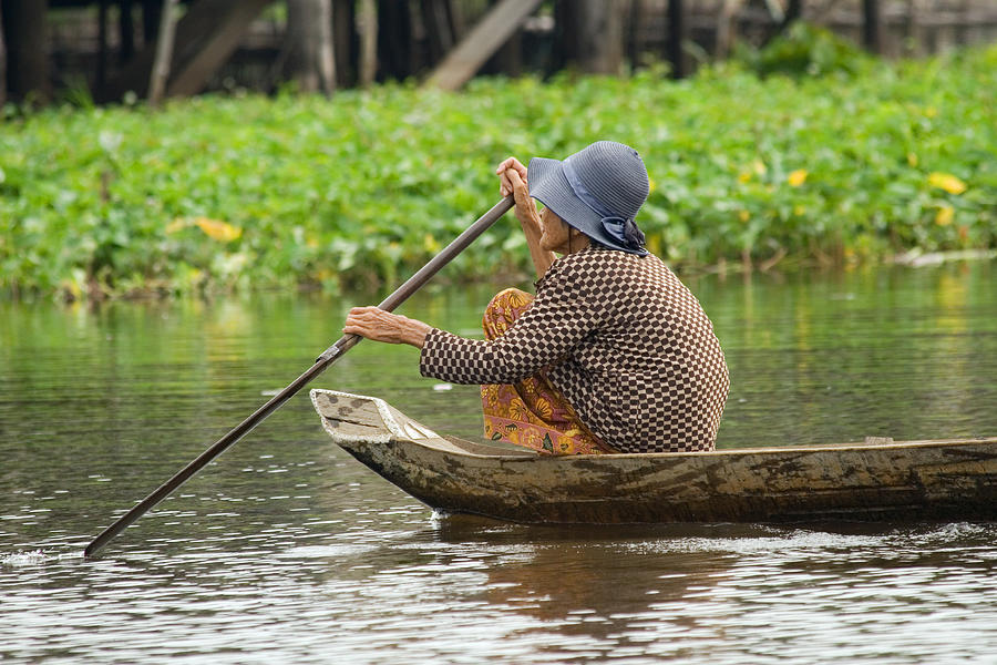 Transportation Photograph - Senior Woman Paddling a Boat by Artur Bogacki