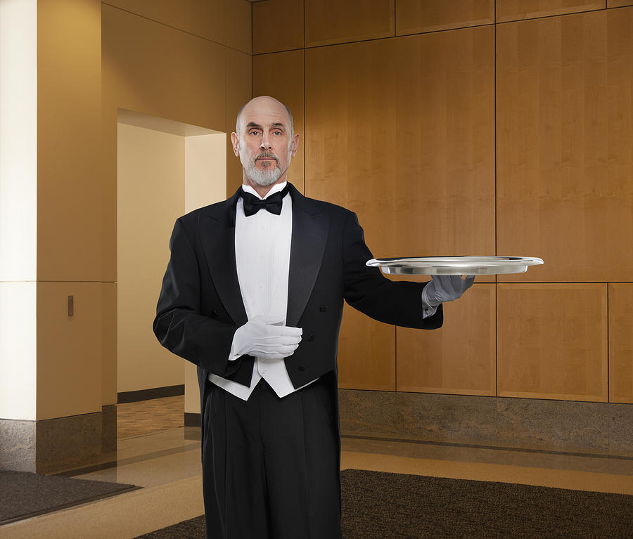 Serious butler holding tray Photograph by John M Lund Photography Inc