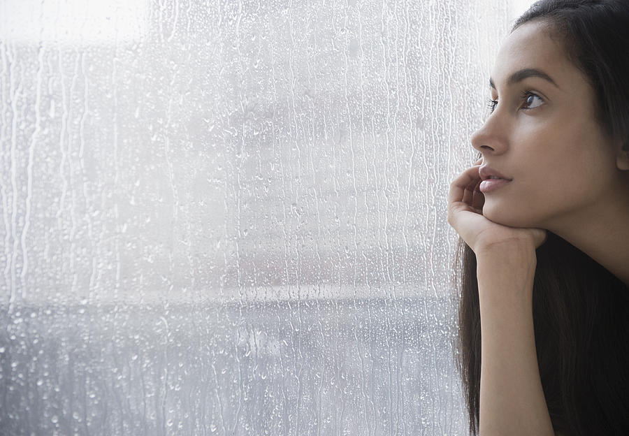 Serious Hispanic teenager looking out window Photograph by Blend Images - JGI/Jamie Grill