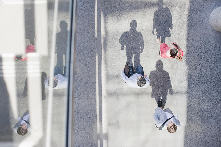 Shadows of people walking from directly above Photograph by Tom Merton
