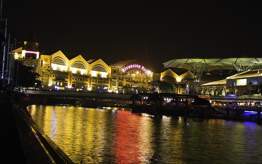 Shimmering lights and reflection in river water at Clarke Quay in Singapore Photograph by Ashish Agarwal