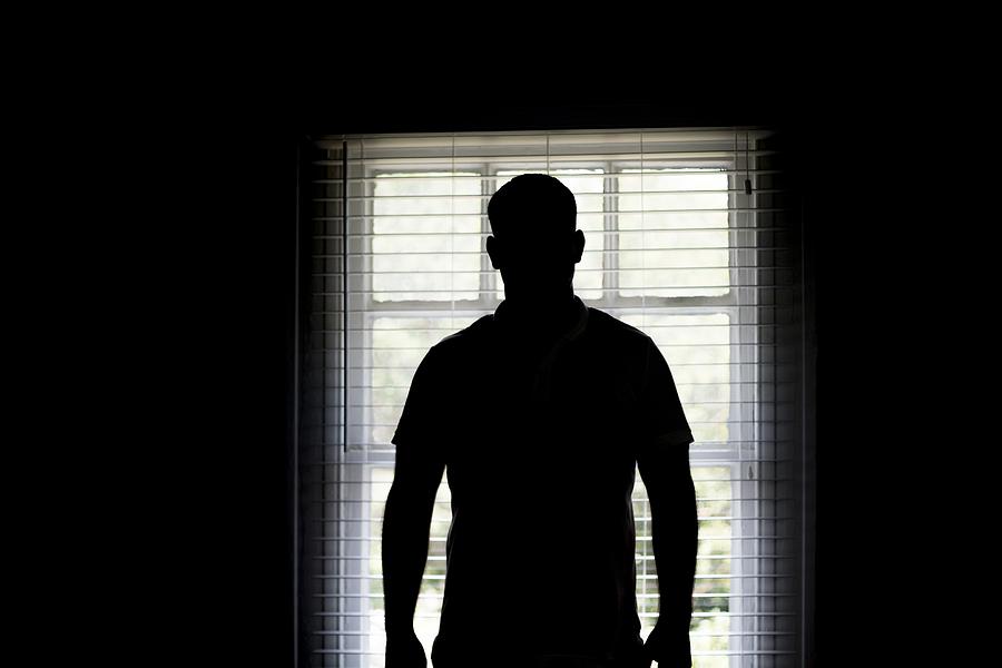Silhouette of a man by a window Photograph by Science Photo Library