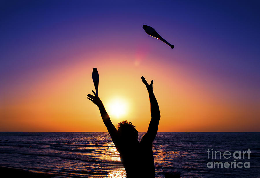 Sunset Photograph - Silhouette of a man man juggling  by Ido Dromi