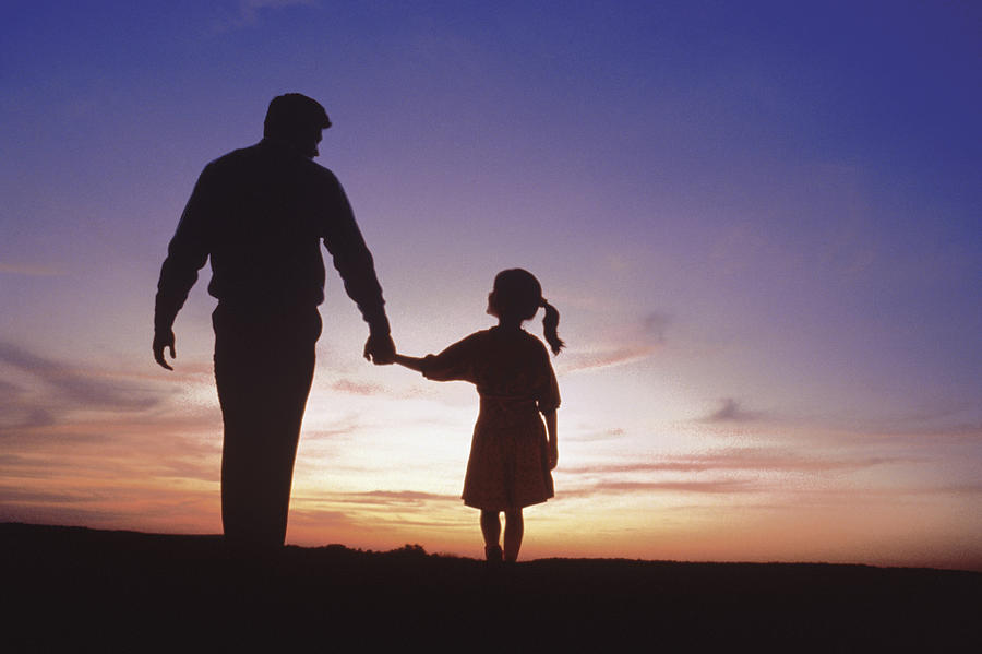 Silhouette of father and daughter walking Photograph by Comstock