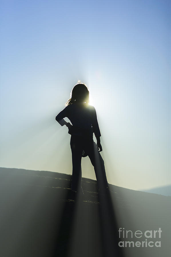 Silhouette of young girl on top of a mountain. Photograph by Don Landwehrle