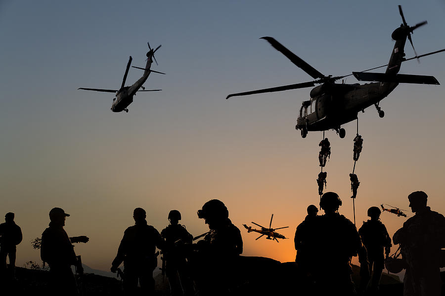 Silhouettes of soldiers on Military Mission at dusk Photograph by Guvendemir