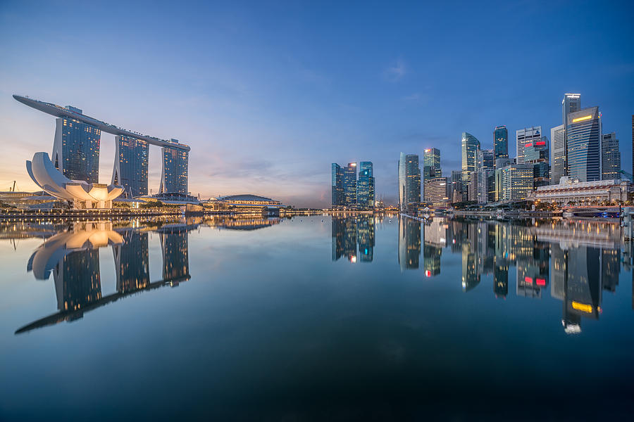 Singapore, Waterfront skyscrapers reflecting in still harbor in evening Photograph by JeremyHui