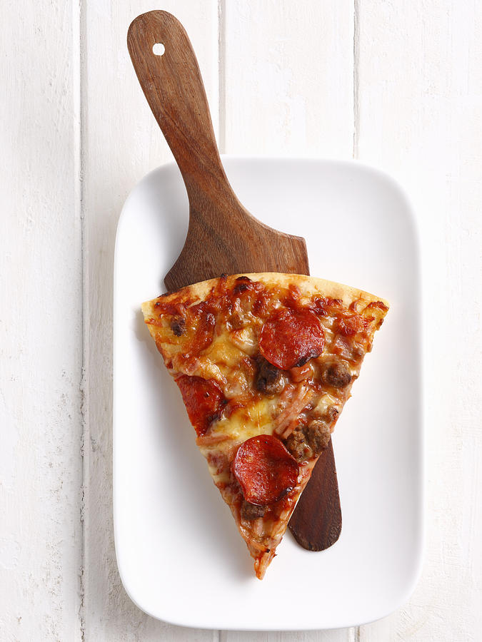 Slice of pizza on platter Photograph by Brett Stevens