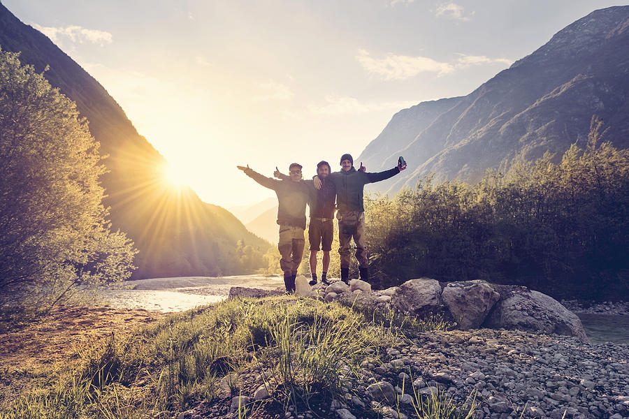 Slovenia, Bovec, three friends at Soca river at sunset Photograph by Westend61