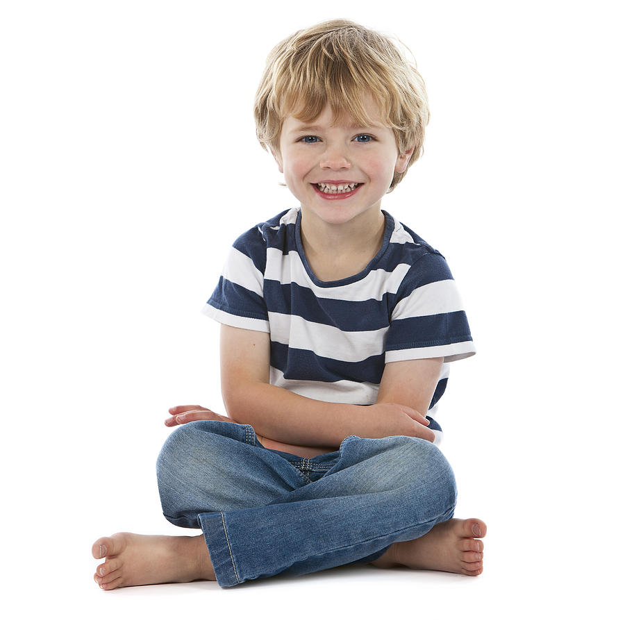 Small boy sitting crossed legged smiling on white Photograph by Jallfree