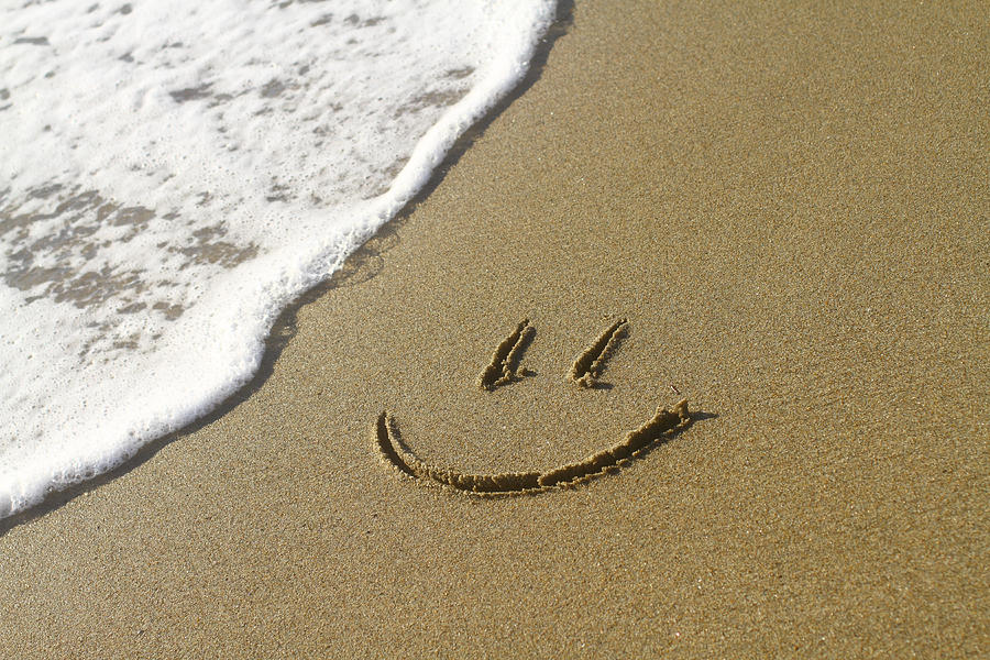 Smiley face on a beach next to a wave Photograph by Barisonal