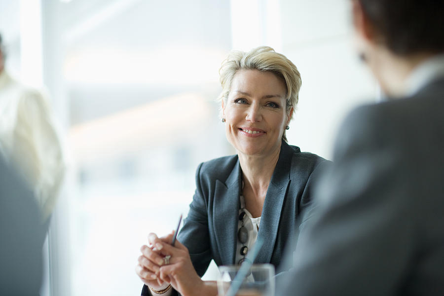 Smiling businesswoman in meeting Photograph by Sam Edwards