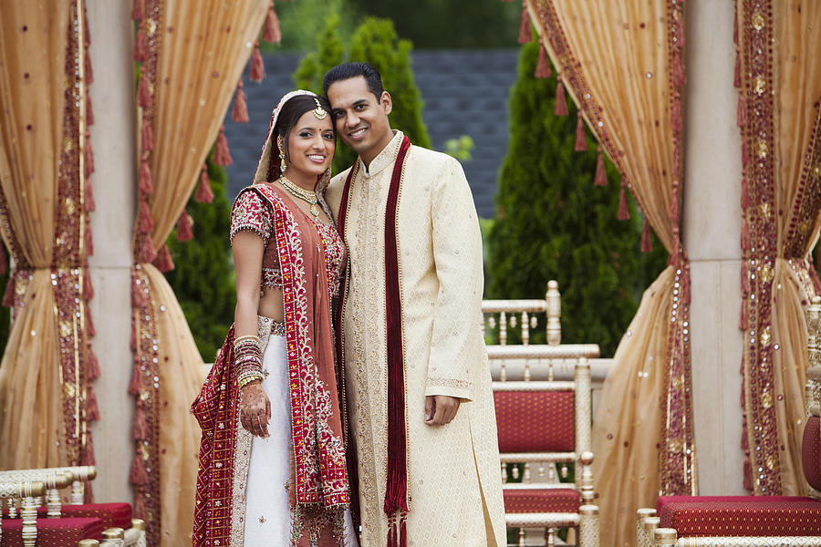 Smiling Indian couple in traditional wedding clothing Photograph by Jihan Abdalla
