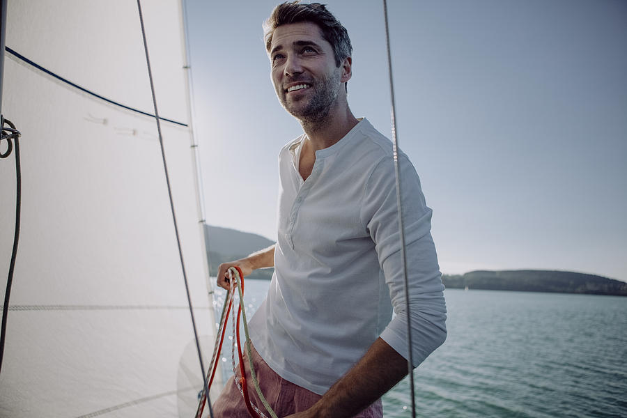 Smiling man standing on a sailing boat Photograph by Westend61