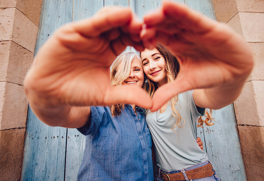 Smiling senior mother and daughter making a heart shape with their hands Photograph by Wundervisuals