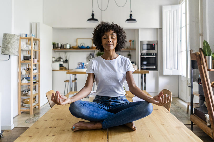 Smiling woman with closed eyes in yoga pose on table at home Photograph by Westend61 Smiling woman with closed eyes in yoga pose on table at home Photograph by Westend61