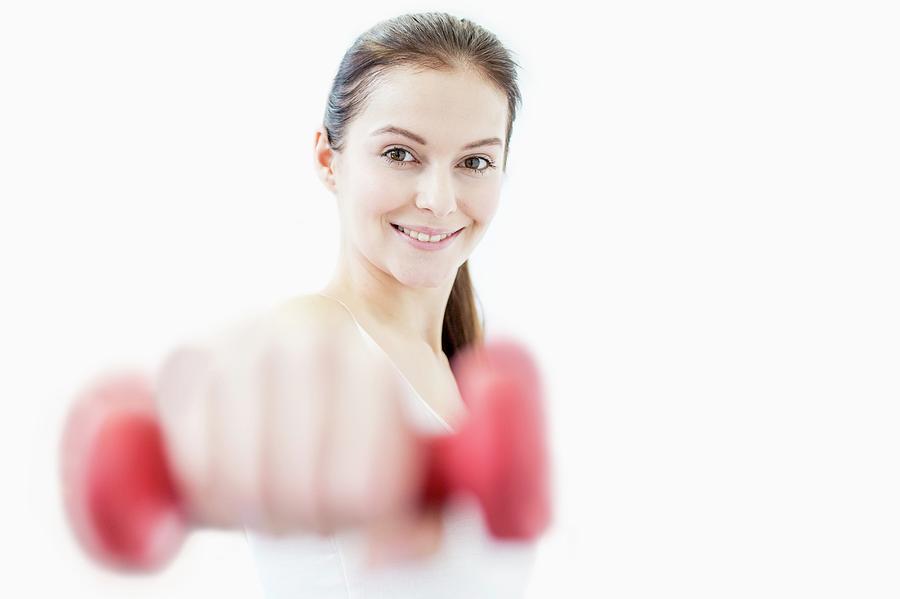 Smiling Young Woman Holding Dumbbell Photograph by Science Photo Library