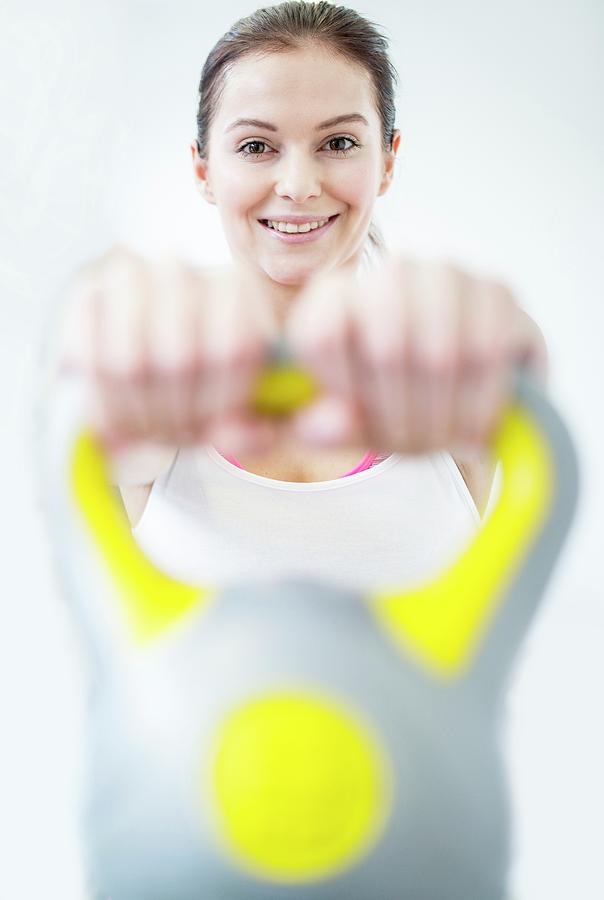 Smiling Young Woman Holding Kettlebell Photograph by Science Photo Library