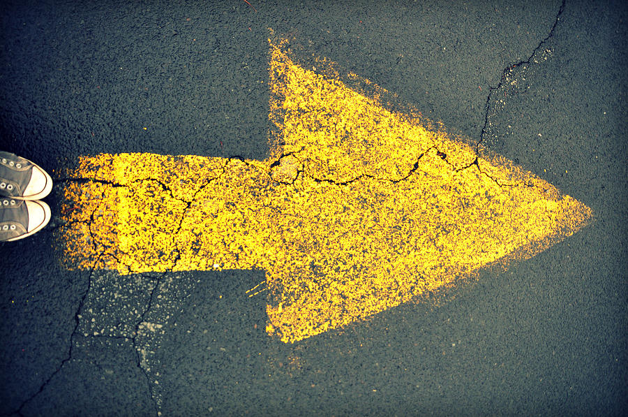 Sneakers and yellow arrow painted on asphalt Photograph by Meredith Winn Photography
