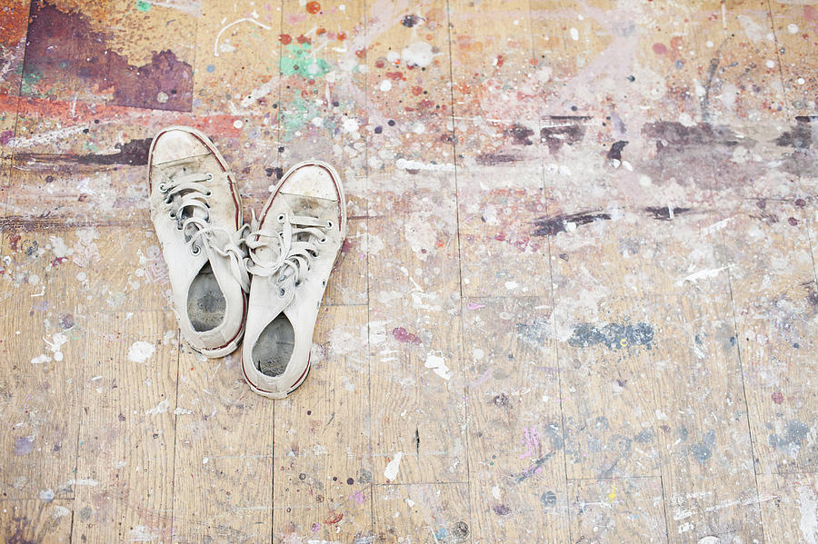 Sneakers on paint-spattered wood floor Photograph by Tom Merton