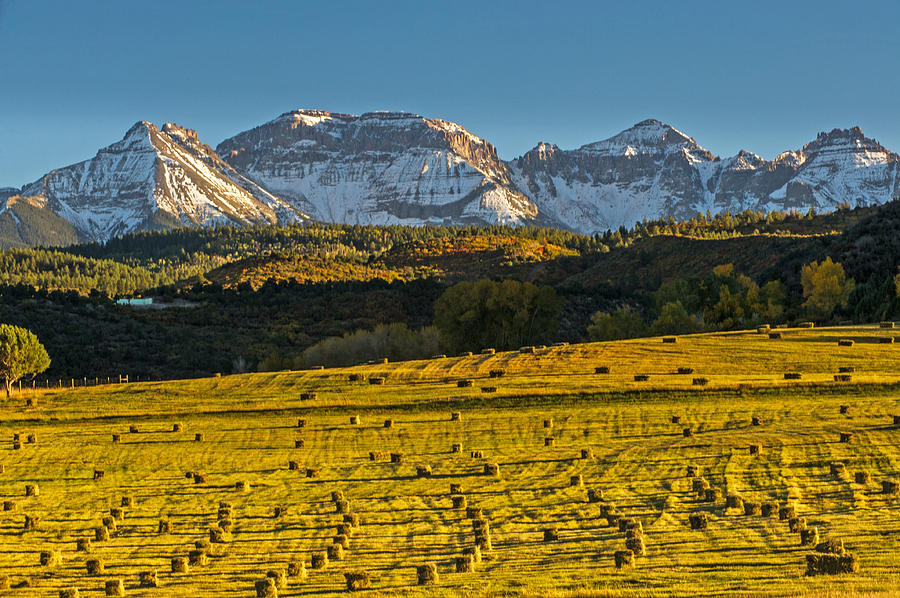 Snow Capped Mountains And Hay Bales at Sunset Photograph by Willie Harper