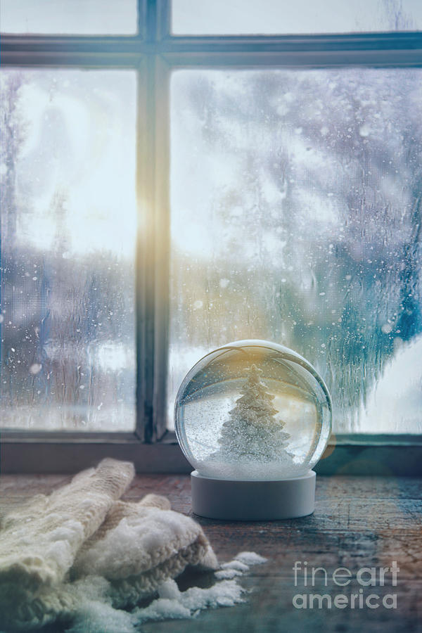 Snowglobe and mittens in front of a window Photograph by Sandra Cunningham