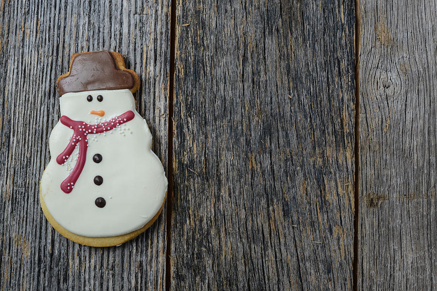 Christmas Photograph - Snowman Cookie on Rustic Wood Background for Christmas by Brandon Bourdages