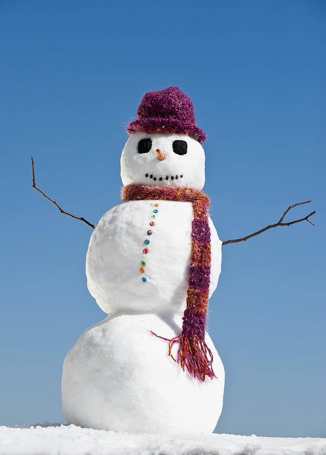 Snowman wearing hat and scarf, clear sky in background Photograph by Tetra Images