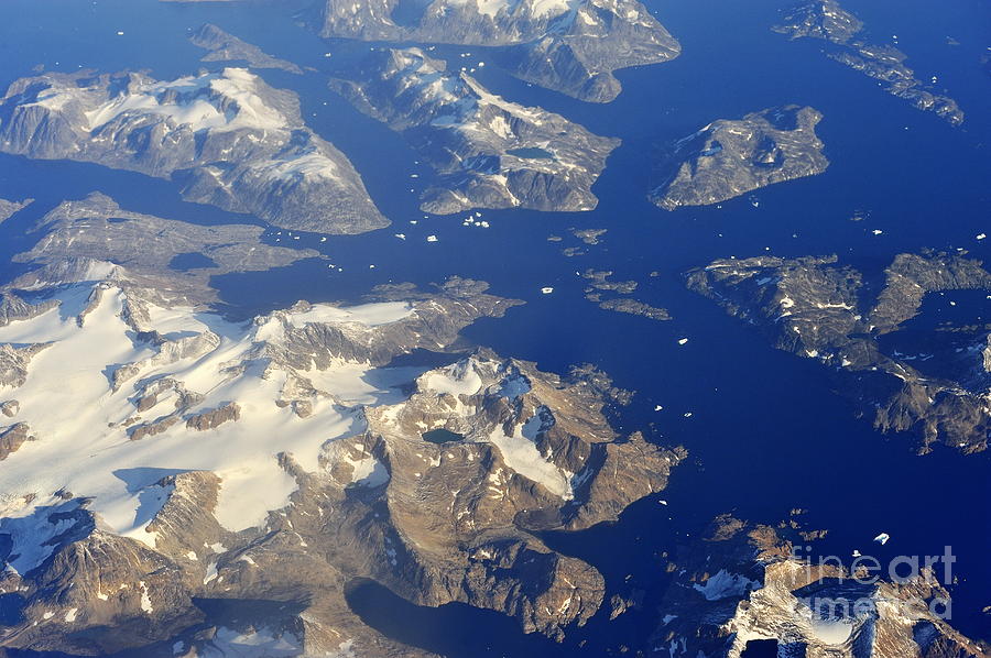 Aerial View Photograph - Snowy rocky islands and floating icebergs on ocean by Sami Sarkis