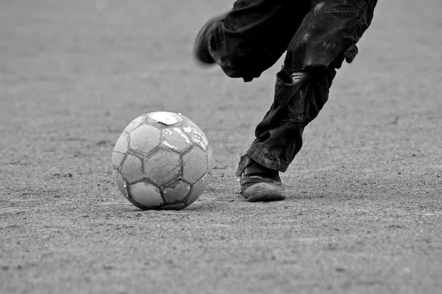 Soccer - Boy is kicking a football - black and white Photograph by Matthias Hauser