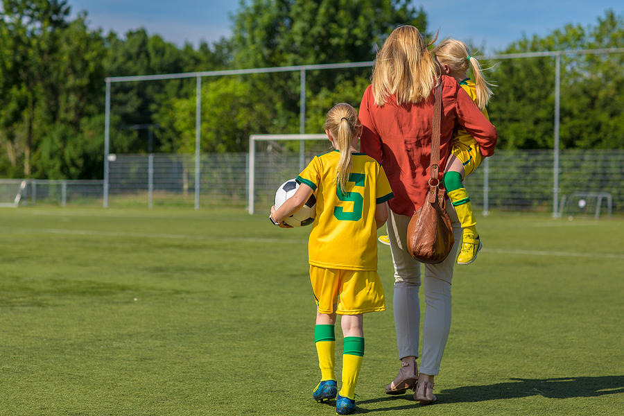 Soccer Mom accompanying her two daughters to football training Photograph by Lorado