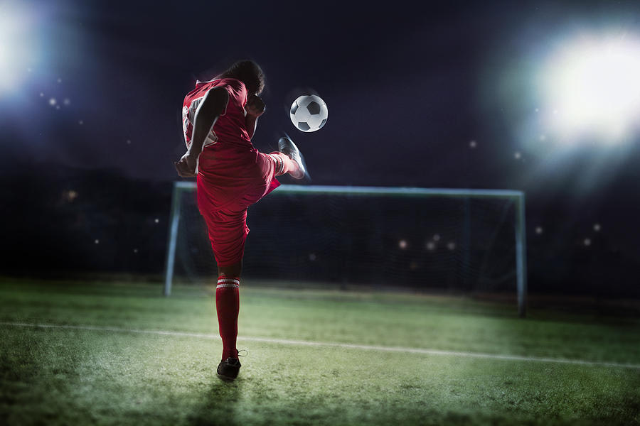 Soccer player kicking ball towards goal Photograph by Shannon Fagan