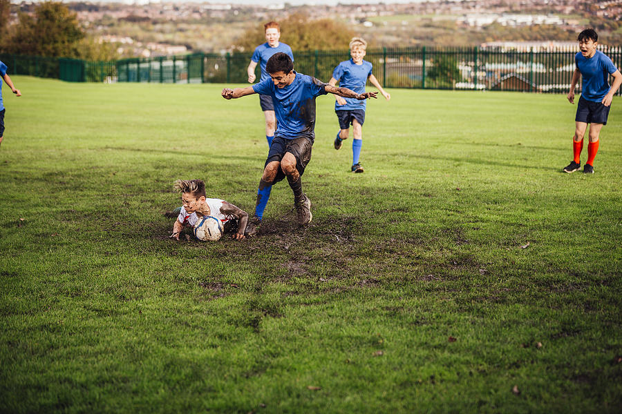 Soccer Player Tackled Down Photograph by SolStock