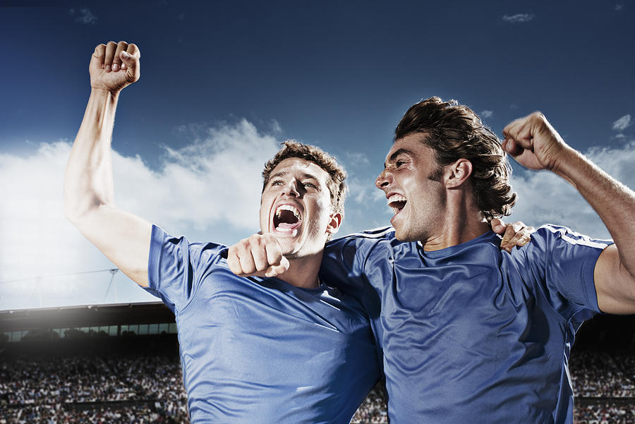 Soccer players cheering Photograph by Paul Bradbury