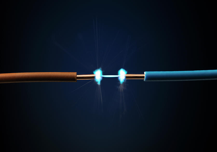 Spark Between Two Cables Against A Blue Photograph by Stuart Minzey