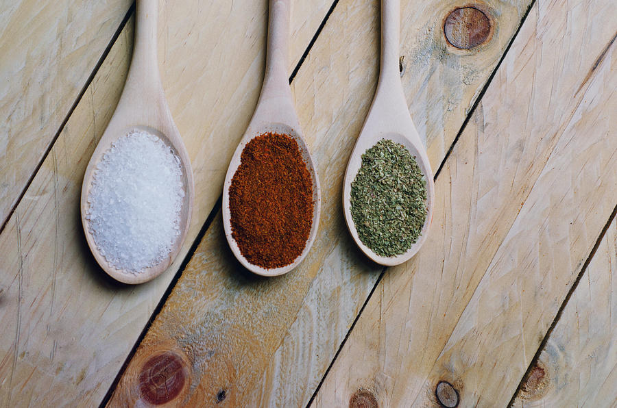 Spices on spoons in wooden background Photograph by Elizabeth Fernandez