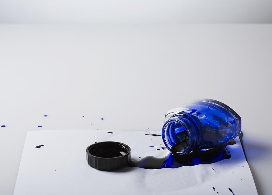 Spilled bottle of blue ink on paper Photograph by Jupiterimages